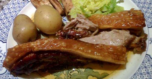 a slice of cooked belly pork with crackling and vegetables